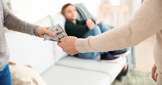 woman handing man money in front of child