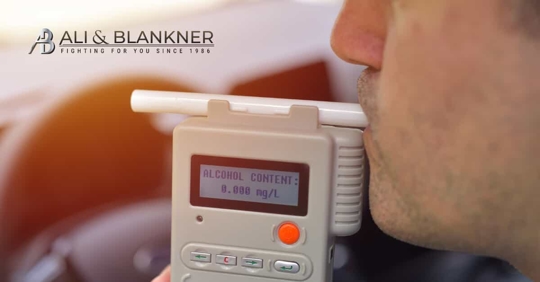 Man taking breath test in his car.