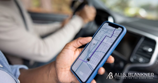 man holds phone with rideshare app opened